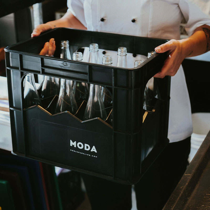 MODA glass bottles in a branded bottle crate